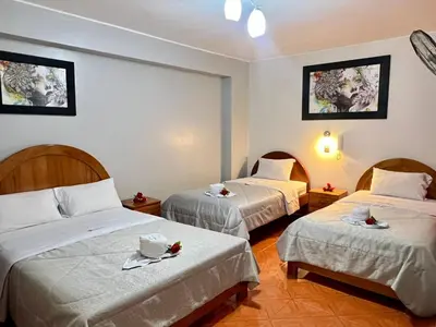 a hotel room with two beds with plates on them at Hotel Mayros in Satipo
