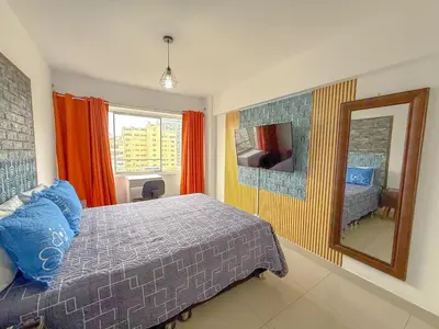 a bedroom with a bed and a mirror and a window at Departamento en el corazón de Miraflores in Lima