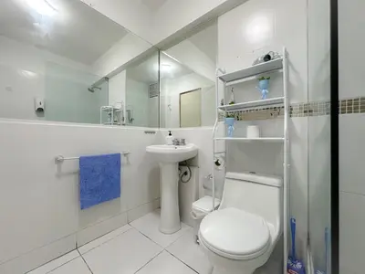 a white bathroom with a toilet and a sink at Departamento en el corazón de Miraflores in Lima