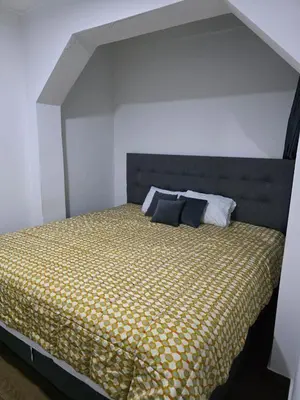 a bedroom with a bed with a yellow comforter at Casa sabina nuevo aeropuerto in Lima