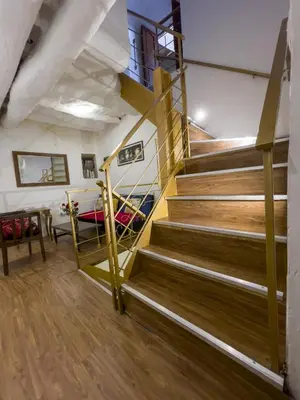 a spiral staircase in a room with wooden floors at Casa Justina in Cusco