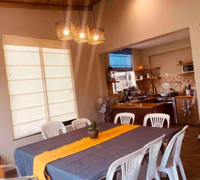 a dining room with a table and white chairs at Casa de Campo Bamboo con Piscina temperada in Lima