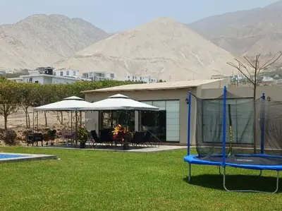 a house with a trampoline in a yard with mountains at Casa de Campo Bamboo con Piscina temperada in Lima