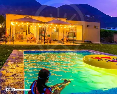 a person in a swimming pool with a raft at Casa de Campo Bamboo con Piscina temperada in Lima