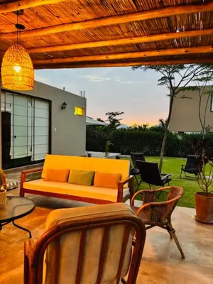 a patio with a couch and a table and chairs at Casa de Campo Bamboo con Piscina temperada in Lima