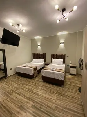 a room with two beds and a flat screen tv at Ciudad Del Sol Hostel in Ica