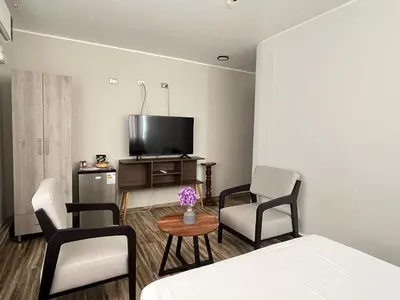 a room with a bed and chairs and a tv at Ciudad Del Sol Hostel in Ica
