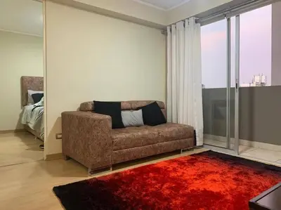 a living room with a couch and a red rug at Vive Cerca a Miraflores Apart. in Lima