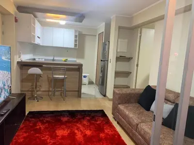 a living room with a couch and a kitchen at Vive Cerca a Miraflores Apart. in Lima