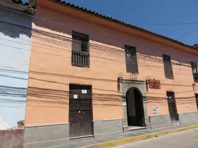 a building with brown doors and windows on a street at Hotel Sevilla in Ayacucho