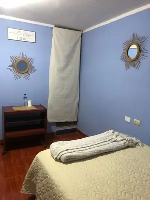 a bedroom with a bed and a blue wall at Pedraza house Airport in Lima