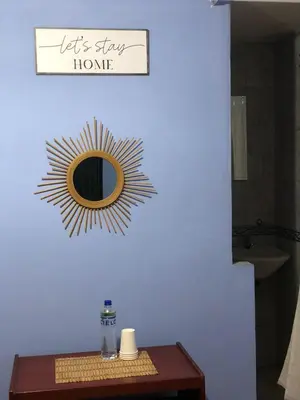 a mirror on a blue wall with a wooden table at Pedraza house Airport in Lima
