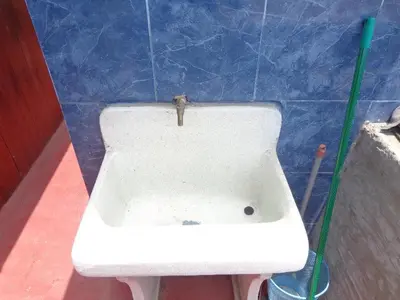 a white sink in a room with a blue tiled wall at Agua dulce in Lima