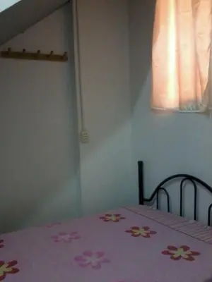 a bed with a pink blanket with flowers on it at Agua dulce in Lima
