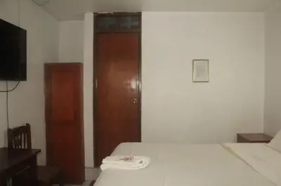 a bedroom with a bed and a wooden door at El Balcon Hostal in Ayacucho