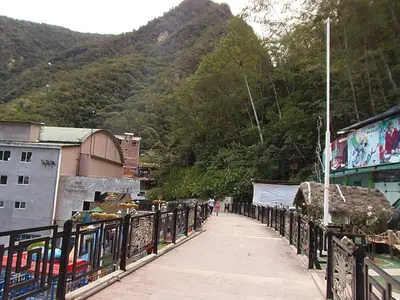 a walkway with a fence in front of a mountain at Hostal Pablo's House in Machu Picchu