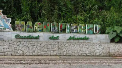 a sign for a park with graffiti on a wall at Hostal Pablo's House in Machu Picchu