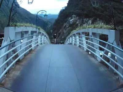 a bridge on a mountain with a person walking on it at Hostal Pablo's House in Machu Picchu