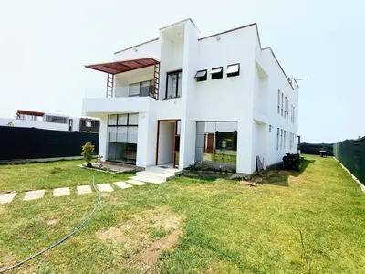 a white house with a large yard at Alquilo Casa playa in San Antonio