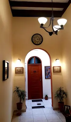 a hallway with a red door and a clock on the wall at Kanata Properties 2 in Lima