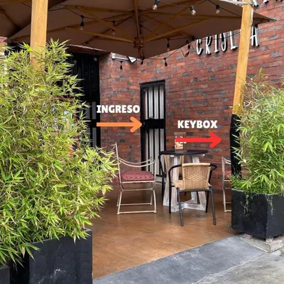 a patio with a table and chairs and a brick wall at Lince Apartments in Lima