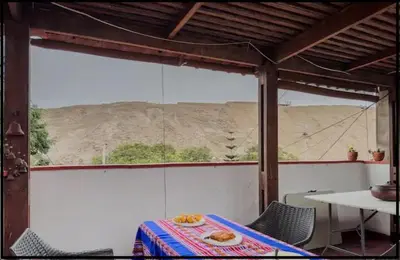 a table and chairs in a room with a view at Casa Huaca in Lima