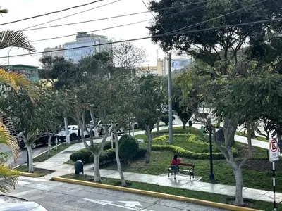 a person sitting on a bench in a park at Casa Huaca in Lima