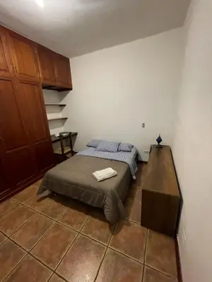 a bedroom with a bed and a desk in it at Casa Huaca in Lima
