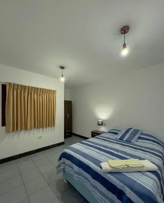 a bedroom with a bed with a blue and white blanket at Casa Huaca in Lima