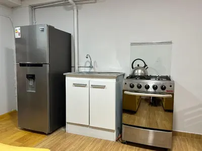 a kitchen with a stove and a stainless steel refrigerator at Skyhousecusco in Cusco