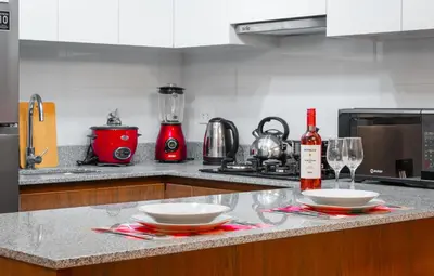 a kitchen with two plates and wine glasses on a counter at Apartamento de Ensueño LINCE in Lima