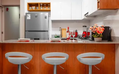 a kitchen with a counter with four bar stools at Apartamento de Ensueño LINCE in Lima