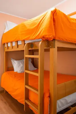 two bunk beds in a room with an orange bed at Apartamento de Ensueño LINCE in Lima