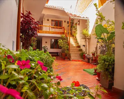 a courtyard of a house with flowers and plants at El Chasqui in Ollantaytambo