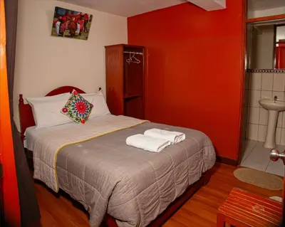 a bedroom with a bed with two towels on it at El Chasqui in Ollantaytambo