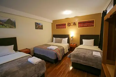 a hotel room with two beds and two ottomans at El Chasqui in Ollantaytambo