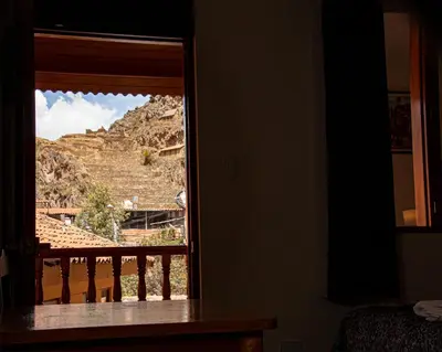 a window in a room with a view of a mountain at El Chasqui in Ollantaytambo