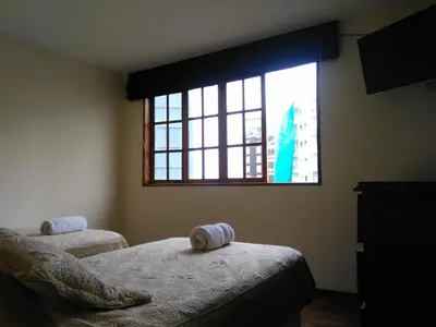 a bedroom with two beds and a large window at Inkawasi Miraflores Hostel in Lima