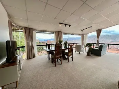 a living room with a table and chairs and a television at Casa Encuentro San Blas in Cusco