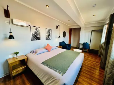 a bedroom with a bed and a desk and chairs at Casa Encuentro San Blas in Cusco