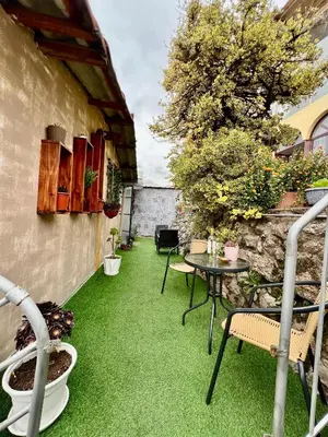 a patio with green grass and a table and chairs at Casa Encuentro San Blas in Cusco