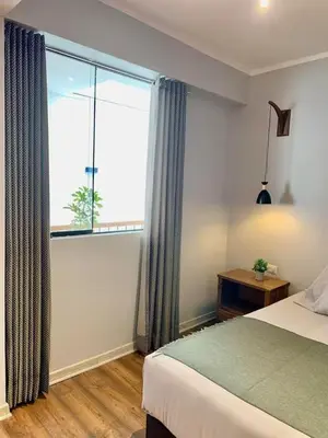 a bedroom with a bed and a large window at Casa Encuentro San Blas in Cusco