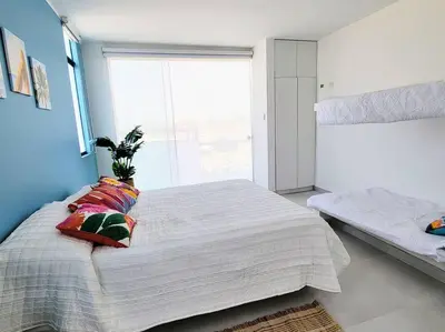 a bedroom with a large bed and a window at HERMOSA CASA CON PISCINA FRENTE AL MAR - PRIMERA FILA in Chincha Baja