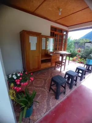 a room with chairs and a table and some flowers at Hospedaje Pinky Lodge in Oxapampa