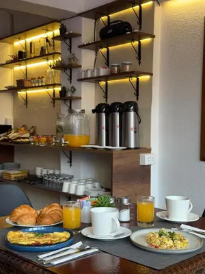 a breakfast table with plates of food and drinks at Casa Tiyay Cusco in Cusco