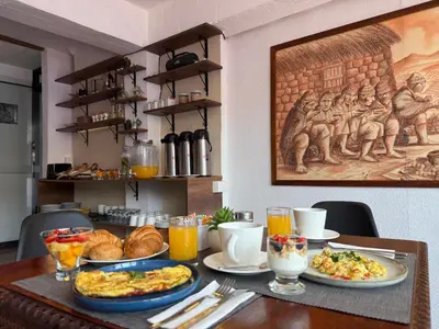 a table with plates of food and drinks on it at Casa Tiyay Cusco in Cusco