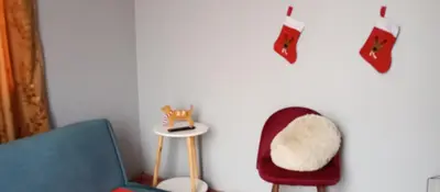 a room with a chair and christmas hats on the wall at Departamento 5p Tierra del Sol Eterno - Ica centro in Ica