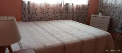 a bedroom with a bed with a blanket and a window at Departamento 5p Tierra del Sol Eterno - Ica centro in Ica