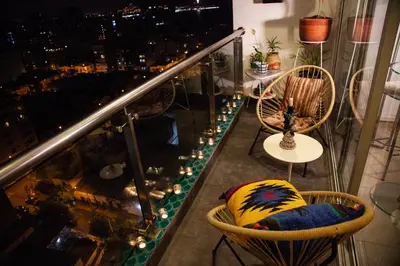 a balcony with chairs and a table and a city at Chic Miraflores AC HEATER 16th floor in Lima