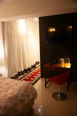 a bedroom with a bed and a desk and a television at Chic Miraflores AC HEATER 16th floor in Lima
